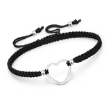 black macrame adjustable bracelet with silver heart shaped charm and beads on white background